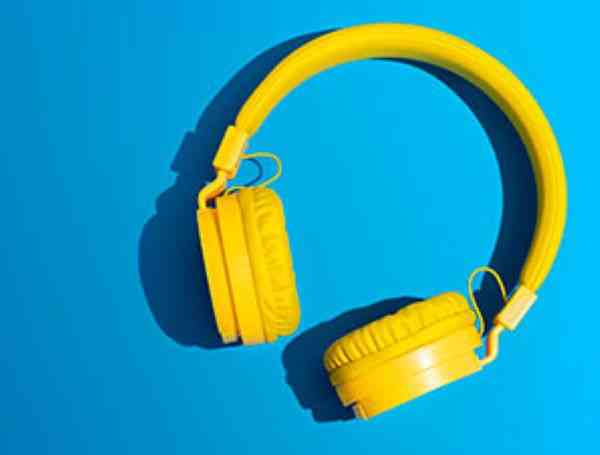 Yellow wireless headphones on vibrant blue background